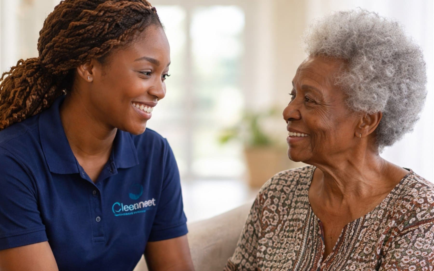A Cleaneet caregiver smiling with an older woman during a home support visit